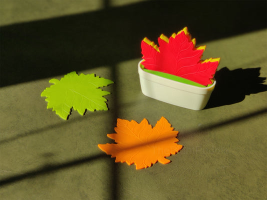 colourful maple leaf shaped coasters on a table