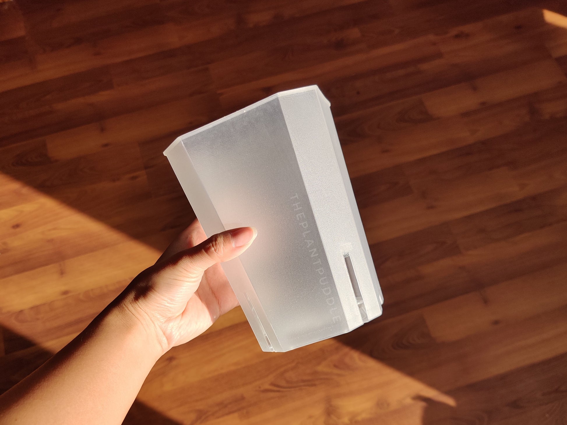 hand holding a square plant pot